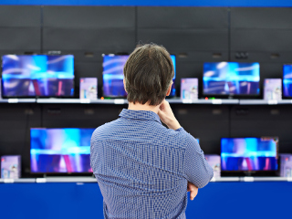 Man looking at TVs
